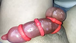 Asian jacking off his red rocket!  His cock engorged using cock rings and a condom.