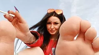 Foot fetish on the beach by the sea. Dominatrix Nika smokes and seduces you with her feet and toes