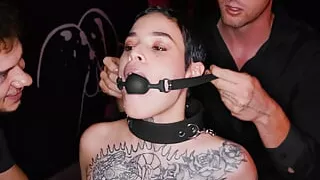 Obedient tattooed slut gets gagged and dominated by two rough guys in BDSM style