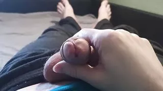 Guy in blue t-shirt jerking off his cock lying on the bed