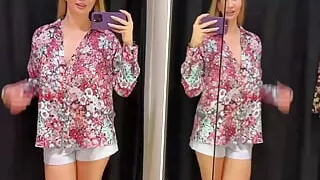 An adult film actress changes clothes in a fitting room