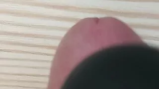 Squeezing dick on the table with magic wand