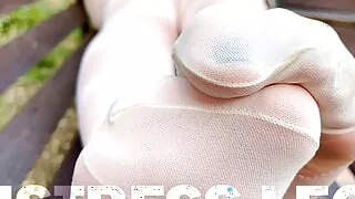 Enjoy seductive nylon feet on a bench in white patterned pantyhose