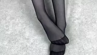 Mistress caresses her feet in black nylon pantyhose