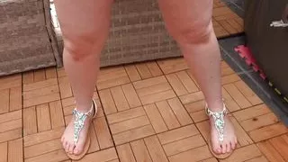 Tarty Wife with big breasts posing in sexy black swimsuit and sandals