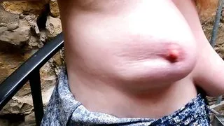 Slapping her naked breasts on public stairs