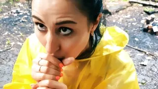 Slutty Brunette in a yellow raincoat sucks me outdoors in the rain