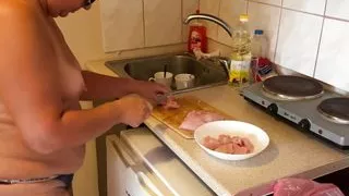 Zara is cooking topless in the kitchen