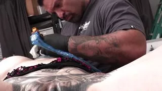 Marie Bossette plays with her toy while being tattooed
