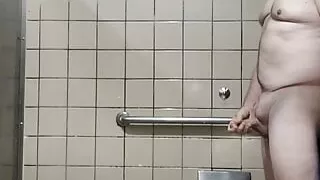 More old guy naked and masturbating in big men's room stall
