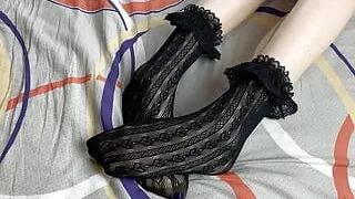 Caressing long legs of girl in black lace socks