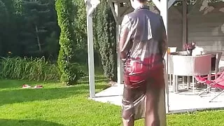 Garden, beautiful sunny day. Wanilianna in transparent raincoat, black seamed nylons