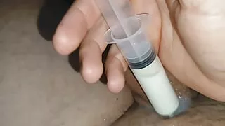 Reintroduction of the boy's load into the cock with the syringe.