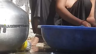 Indian stepsister is preparing to take a bath while washing clothes in the open courtyard of the house