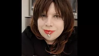 Sissy Kelli walks a hotel corridor wearing a penis gag