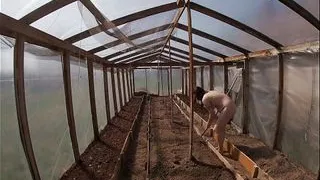 Nude house wife working in the greenhouse