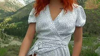 Redhead beauty in a dress against the backdrop of nature masturbates her pussy