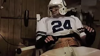 Football jock lifting weights with plug