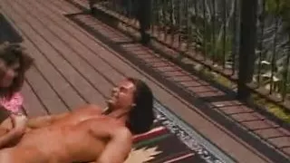 A tanned babe with big tits rides dick on the balcony