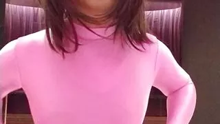 A cross-dressing boy masturbates wearing pink full-body tights up to his head.
