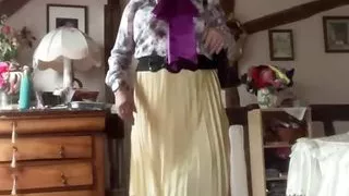 In bourgeoise attire with a pleated yellow skirt for the day