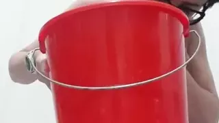 Milf Julie sits on bucket and squirts