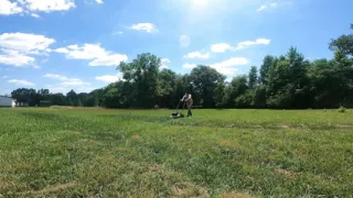 Jon Scarecrow completely naked  in cowboy boots push mowing the grass