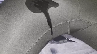 Young blonde guy in dark gray legginds sitting flooding towel