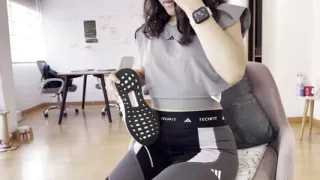 A Woman Warms up After the Gym by Touching Her Sweaty Feet