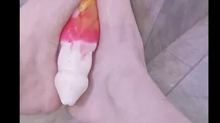 Femboy gives barefoot and bare-legged footjob to dildo