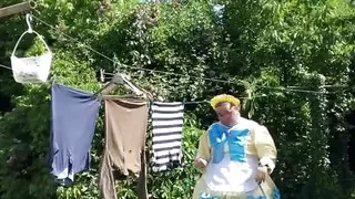 In an outfit with a yellow and blue maid dress to hang the laundry.