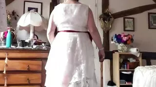 In an outfit with a long white lace dress styled like a wedding dress for an evening.