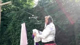 In schoolgirl outfit to hang the laundry