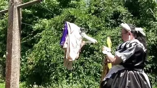 In a black and white maid outfit to hang out the laundry.