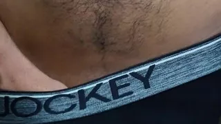 Young man wearing black underwear is dancing cock while holding his groin area.