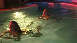 Two sexy lesbian chicks are swimming together in the swimming pool
