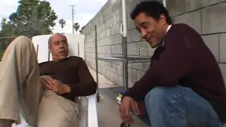 White girl is on the ground showing her tits and sucking two cocks