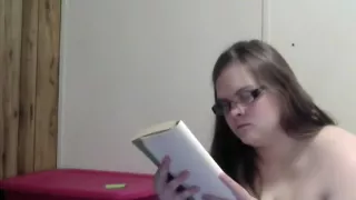 Nerdy pregnant girl reading naked in bed