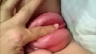 Using her cunt lips that are distended