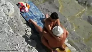 Outdoor voyeur of nude couple on beach having hot sex