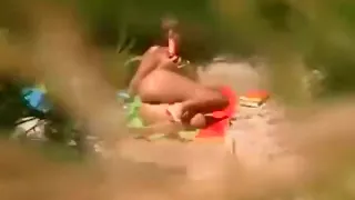 Voyeur fängt ein Mädchen ein, das in der Öffentlichkeit in den Dünen mit sich selbst spielt