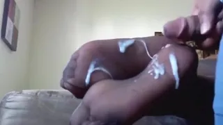 black guy gets a footjob for his girlfriend  and he cums on her feet