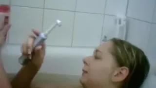 blonde german girl teases her boyfriend  by masturbating her shaved pussy with an electrical toothbrush in the bathtub