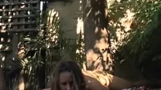 Brunette girl with small tits fingers her shaved pussy on a sheet in nature and moans