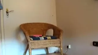 Brunette plays with a dildo on a chair and moans