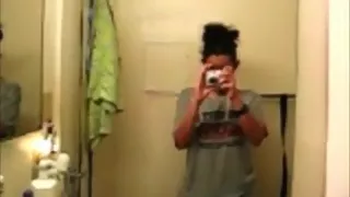 girl strips in front of the bathroom mirror and rubs her hairy pussy on the toilet