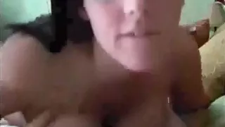 Hot busty brunette girl rubs her shaved pussy closeup on her bed