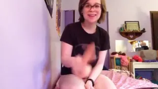 Nerdy girl, fan of batman, fucks herself with a dildo on her bed.