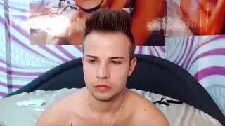 Süßer Mann spielt im Schlafzimmer und hält sich vor der Webcam fest