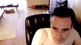 Ein frecher Mann entspannt sich in der Wohnung und filmt sich selbst mit der Computer-Webcam